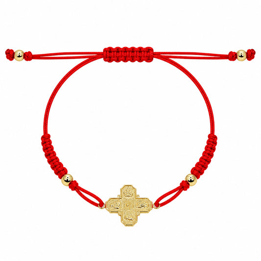A 14k gold 4-way cross pendant on a red macrame bracelet with gold-filled bead accents.