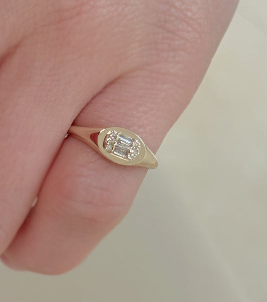 Gold ring with a diamond on a finger against a neutral background