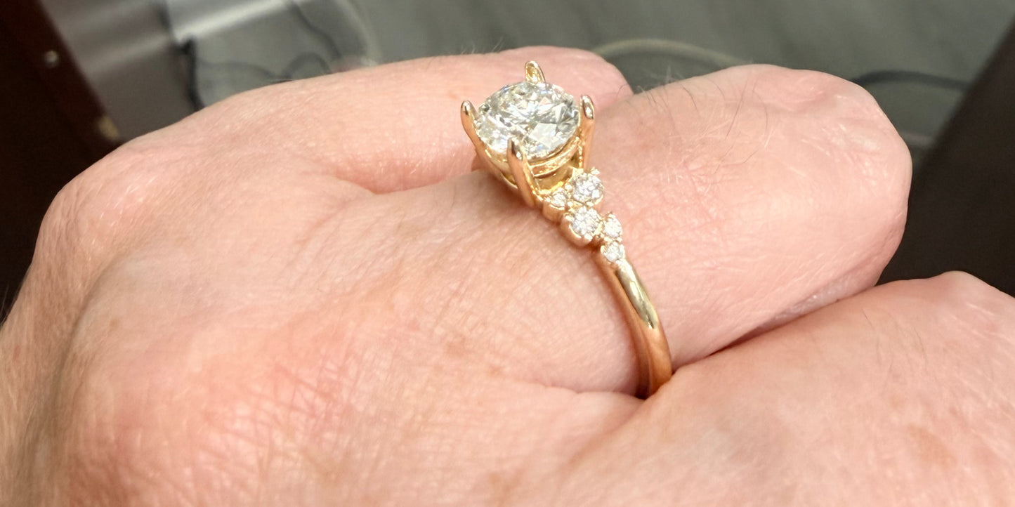 Angled view of a Gold engagement ring with diamonds on a hand