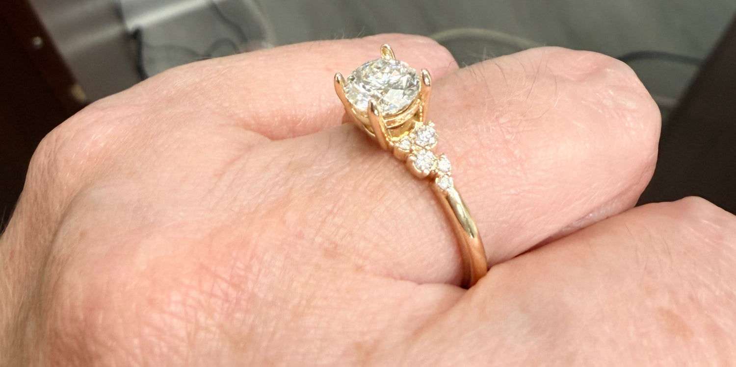 Angled view of a Gold engagement ring with diamonds on a hand