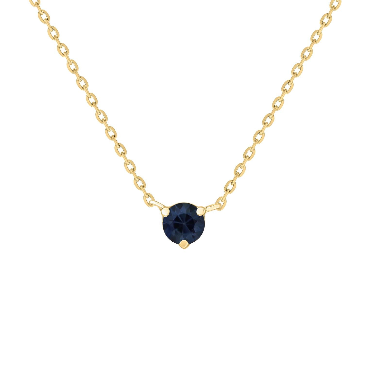 A gold necklace featuring a solitaire blue sapphire gemstone as the centerpiece, with a subtle sparkle.