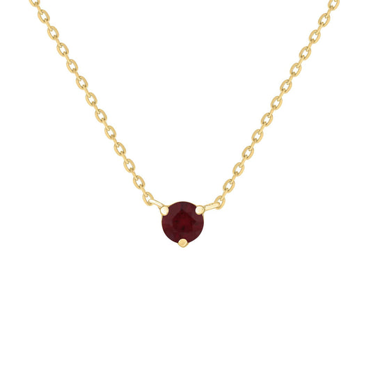 A gold necklace featuring a solitaire ruby gemstone as the centerpiece, with a subtle sparkle.