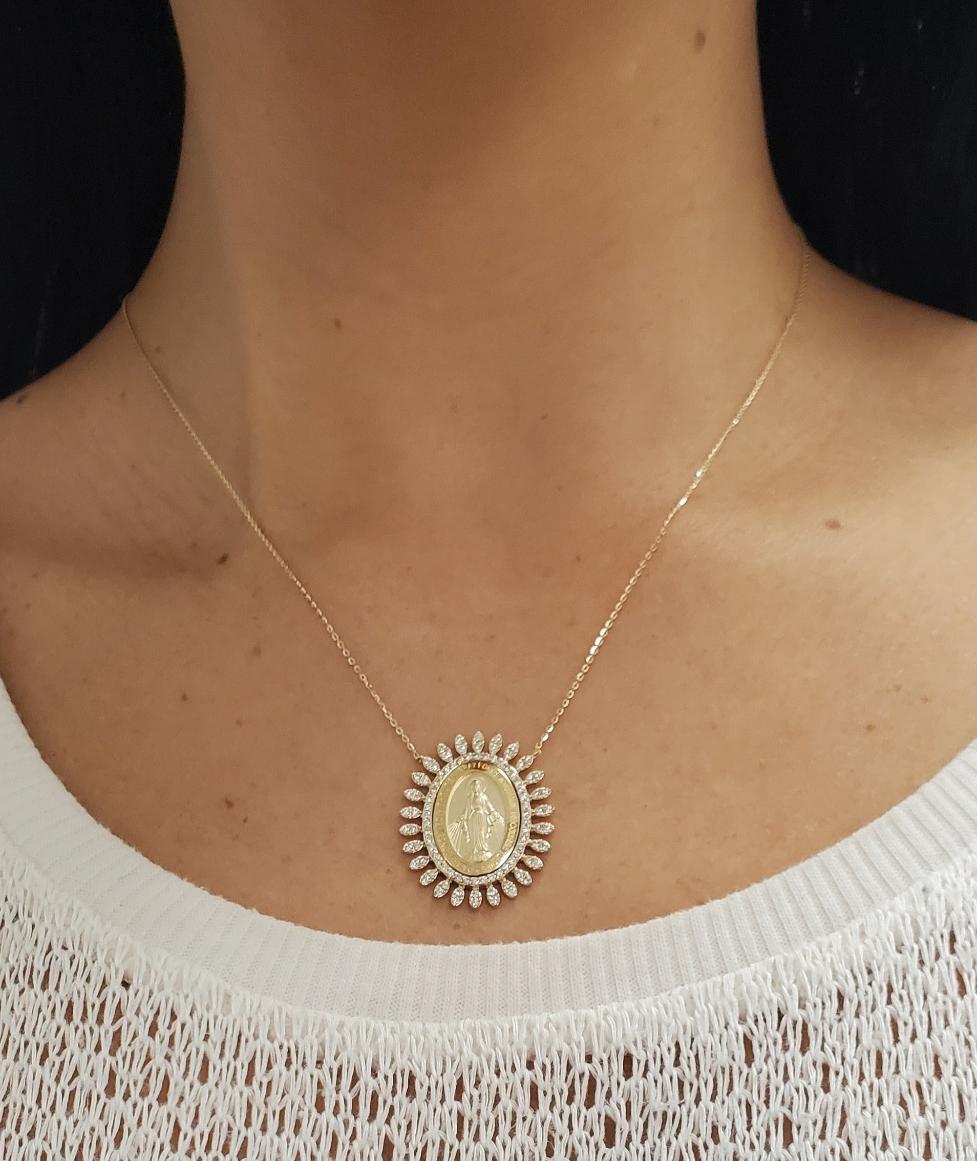 Necklace with a pendant worn by a person against a neutral background