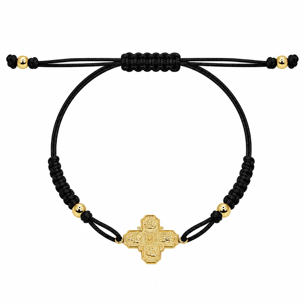 A 14k gold 4-way cross pendant on a black macrame bracelet with gold-filled bead accents.