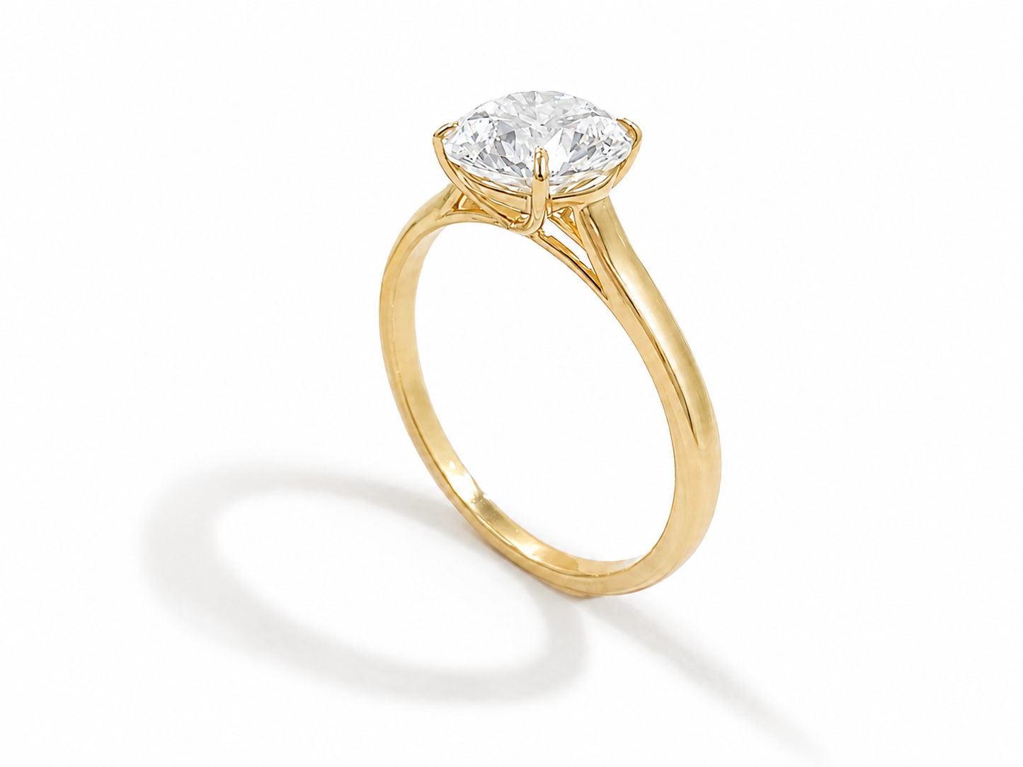 A yellow gold solitaire engagement ring featuring a round-cut diamond, set against a clean white background with a soft shadow.