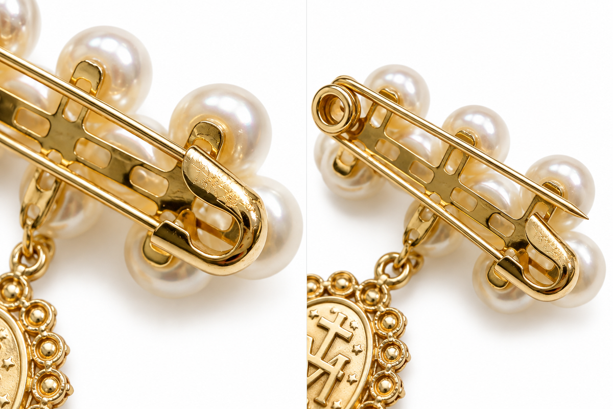 Close-up of a gold safety-pin style brooch with white faux-pearl beads and a dangling gold charm, shown in two angled views on a white background.