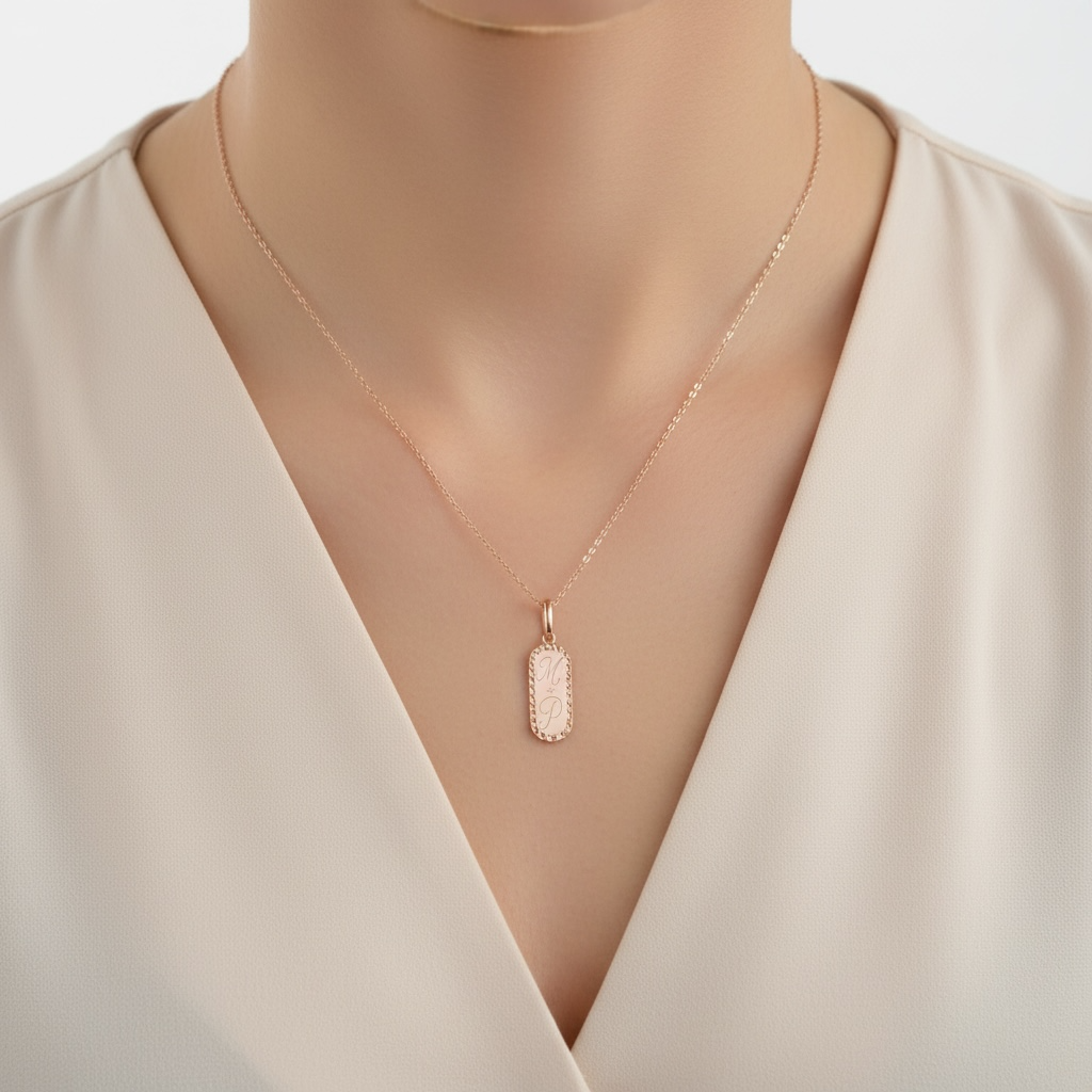 Necklace with a pendant on a woman's neck engraved with M + P wearing a beige top