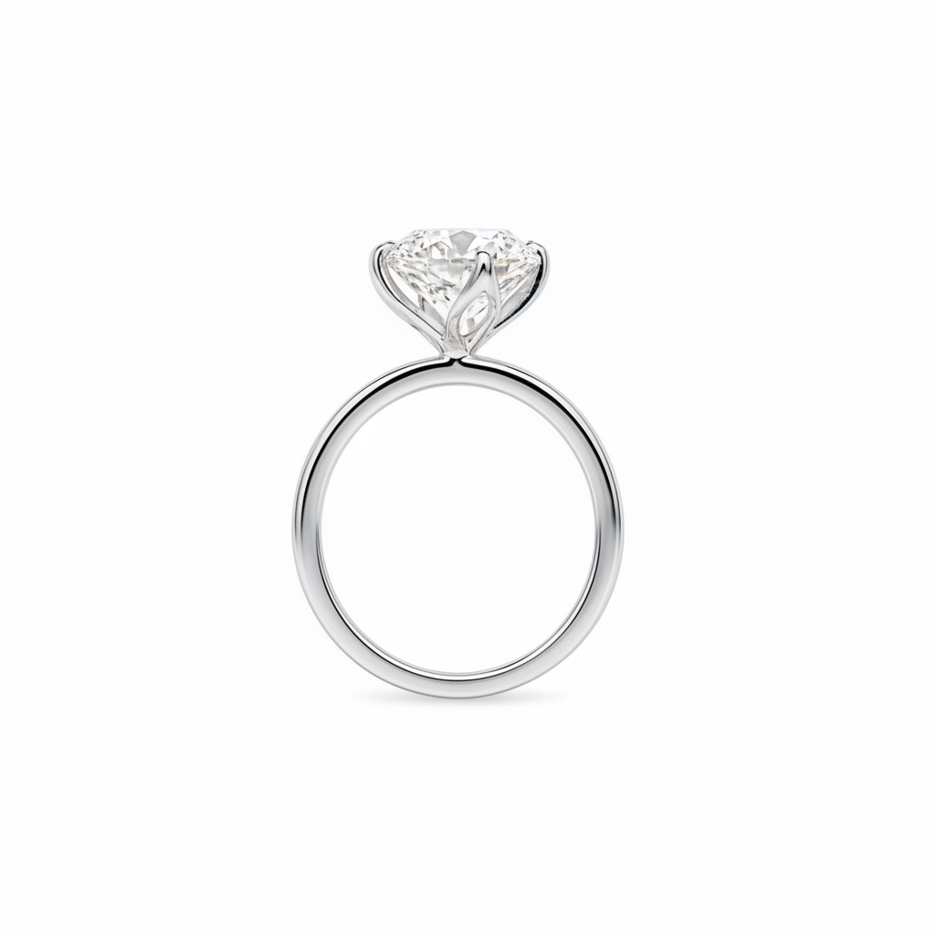 A classic solitaire engagement ring featuring a round brilliant-cut diamond set in a polished white gold or platinum four-prong setting, shown against a seamless white background.