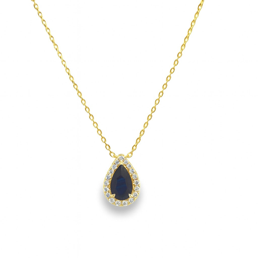 Gold necklace with a blue sapphire teardrop pendant with diamonds on a white background