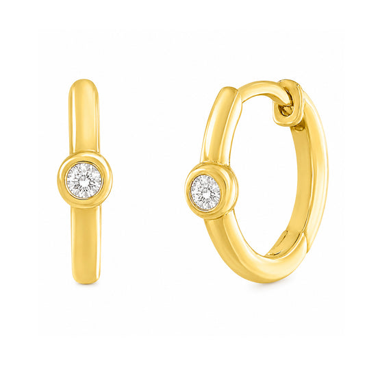 A pair of gold huggie hoop earrings, one shown from the front and the other from the side, each featuring a bezel-set round diamond gemstone on a white background.