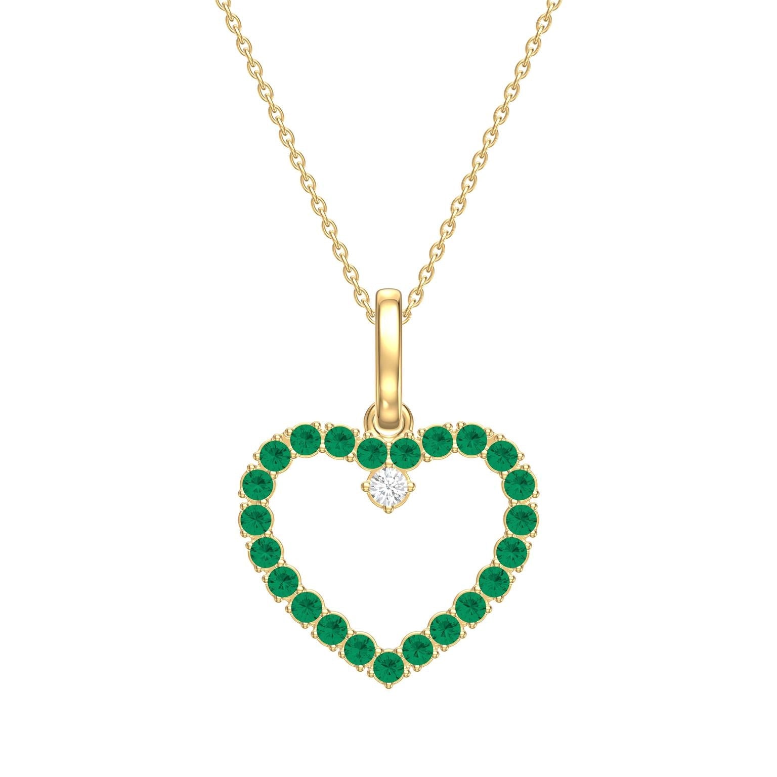 Heart-shaped pendant with green emerald gemstones and a diamond, on a gold chain against a white background.