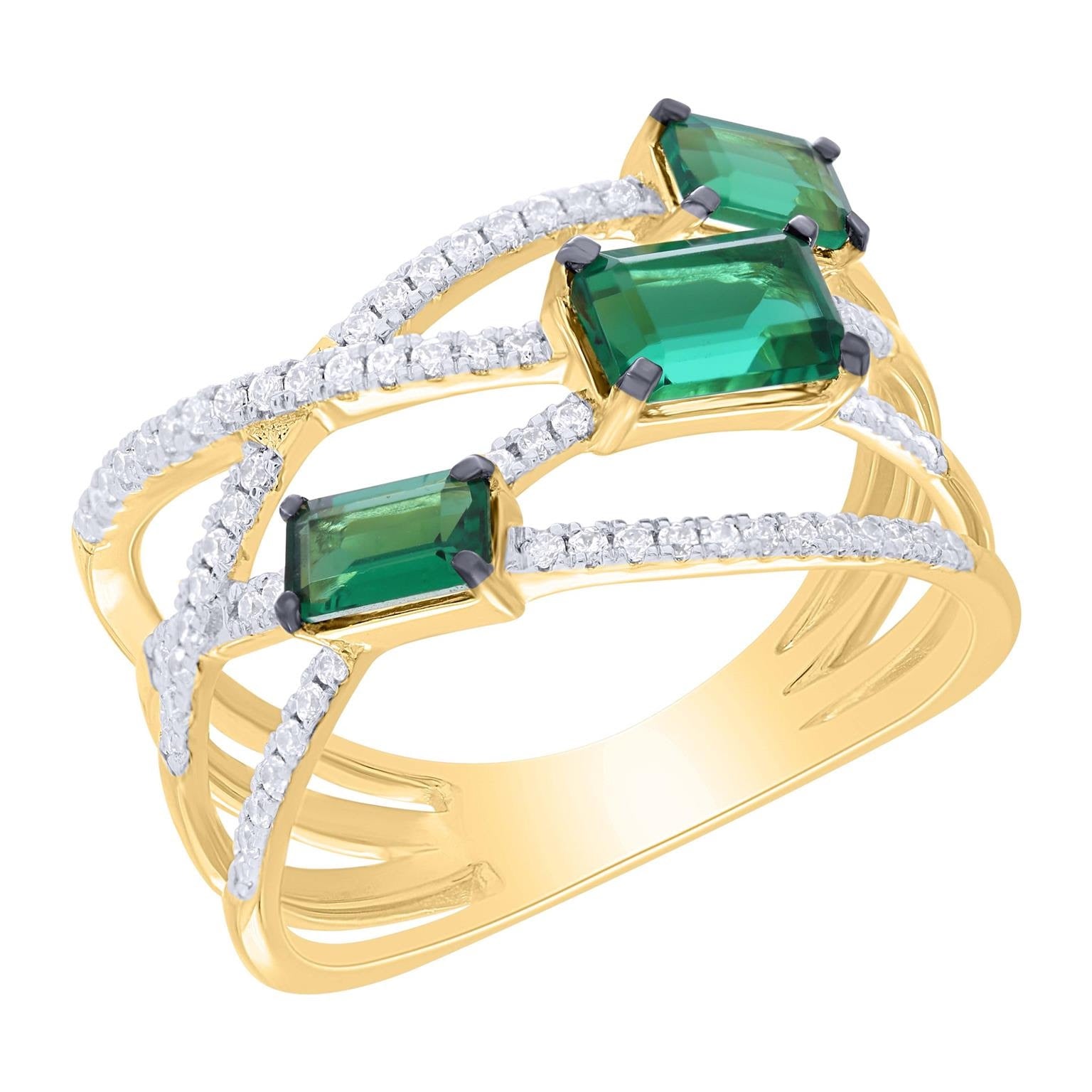 Gold ring with emerald green gemstones and diamonds on a white background