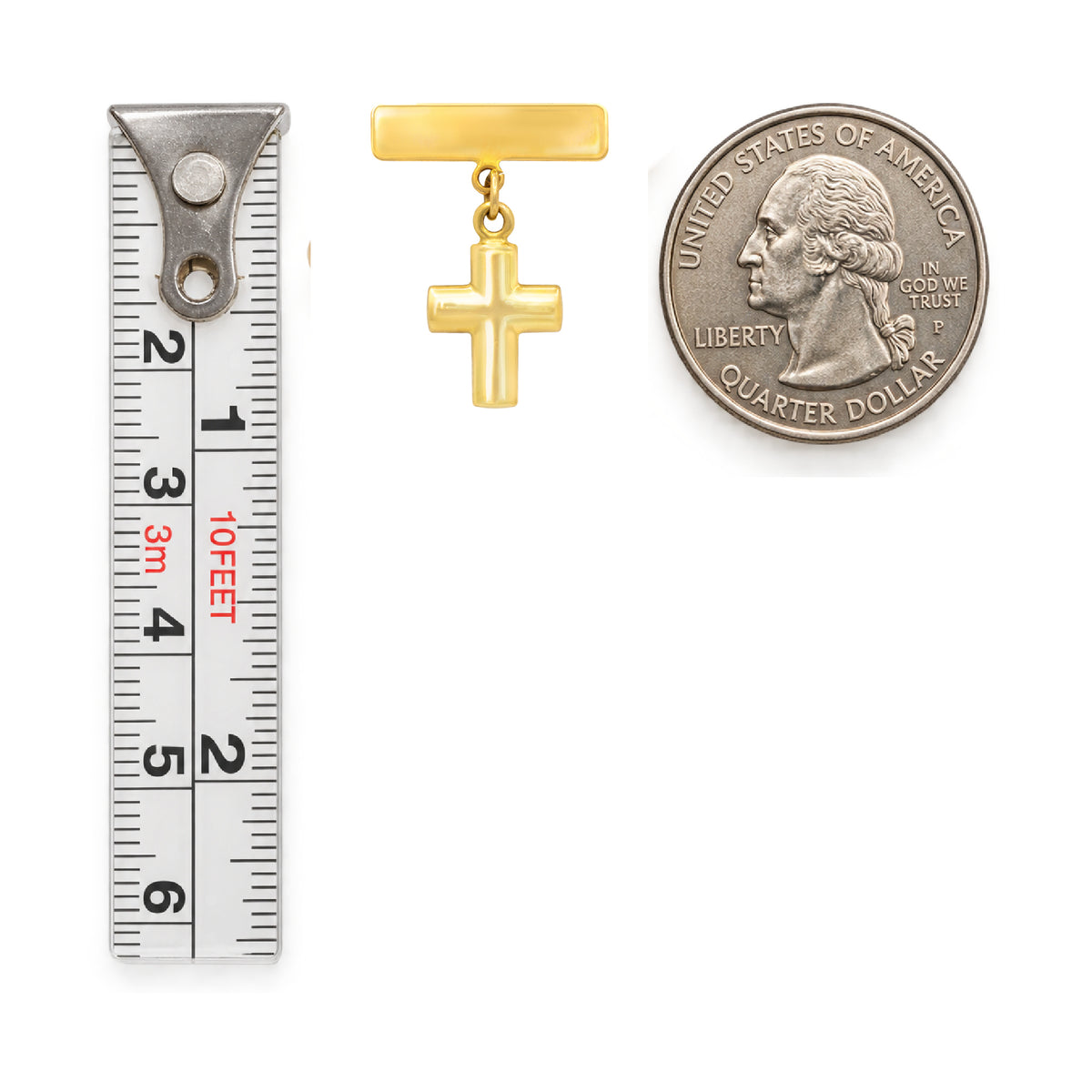 A small gold cross pendant name plate baby pin  shown next to a metal ruler for size reference and a U.S. Quarter Coin.