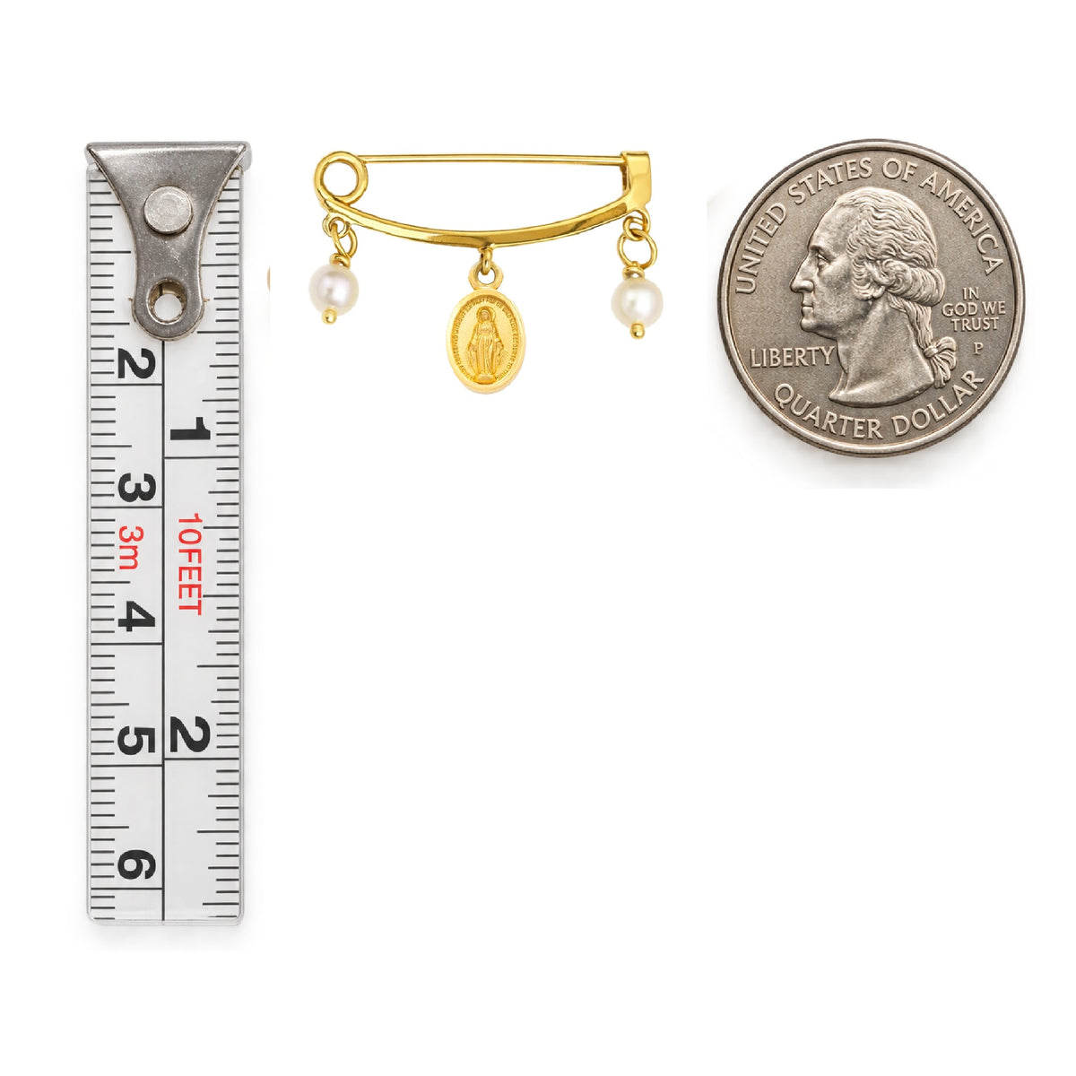 A gold pin with a small oval religious Miraculous Med and two pearl beads, shown next to a ruler on the left and a U.S. Quarter on the right