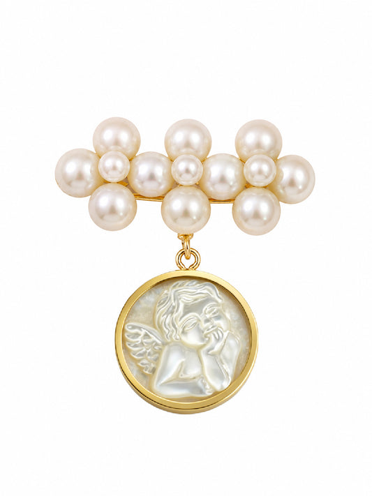 A pearl and gold pendant brooch featuring a cluster of white pearls at the top and a dangling round gold medallion with a white carved cherub figure, shown on a plain white background.