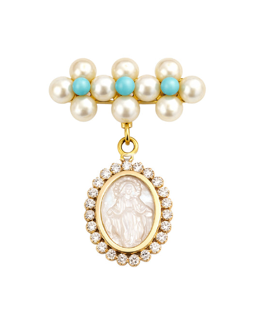 A gold-tone pendant brooch featuring a row of white pearls with turquoise accents at the top and a dangling oval pendant with a white mother of pearl Miraculous Medal figure surrounded by clear cubic zirconia stones, set against a plain white background.