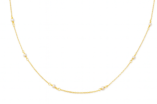 Gold necklace with small pearls on a white background