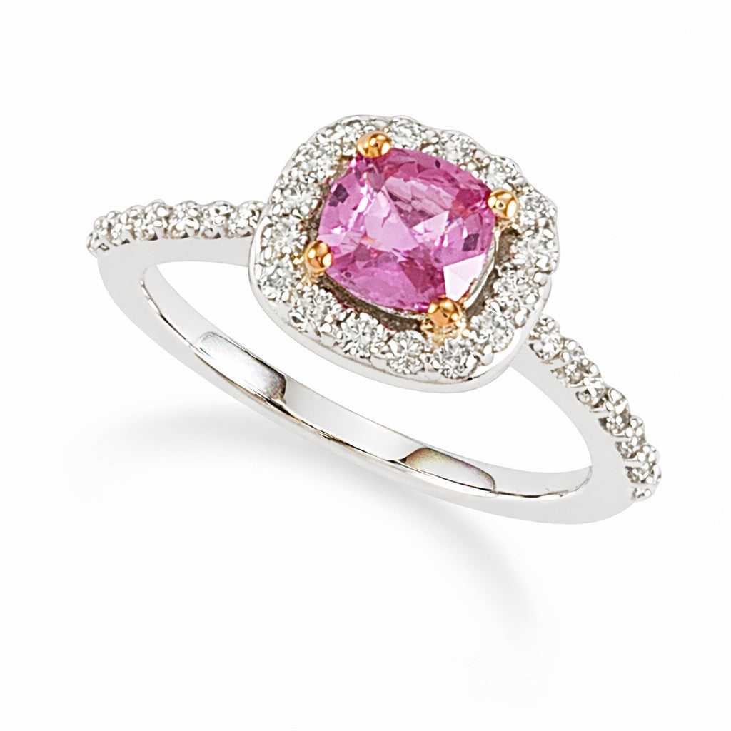 A cushion cut pink sapphire gemstone ring with a halo of white diamonds set in 18K white gold.