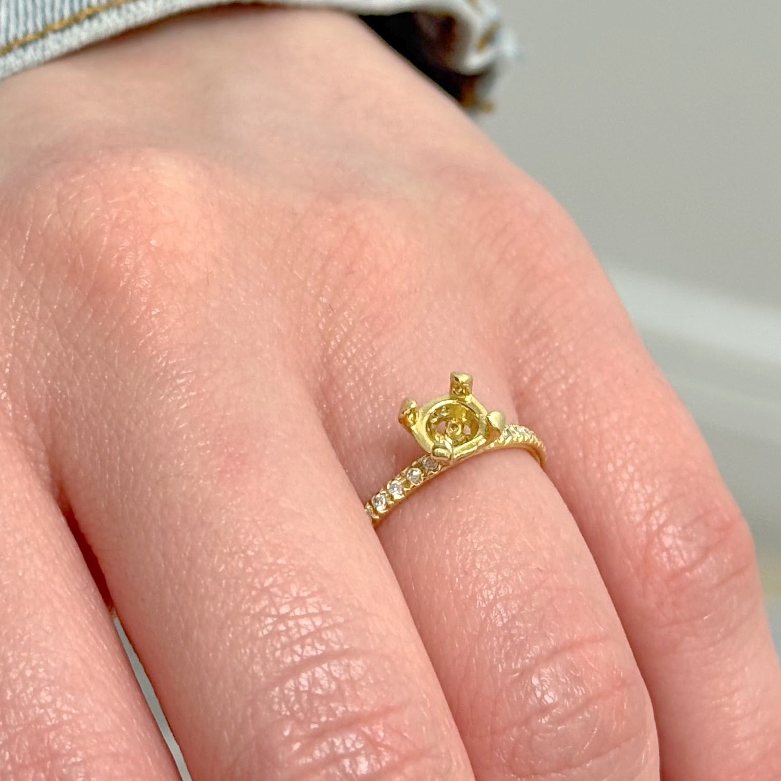Gold ring with a crown design on a person's finger