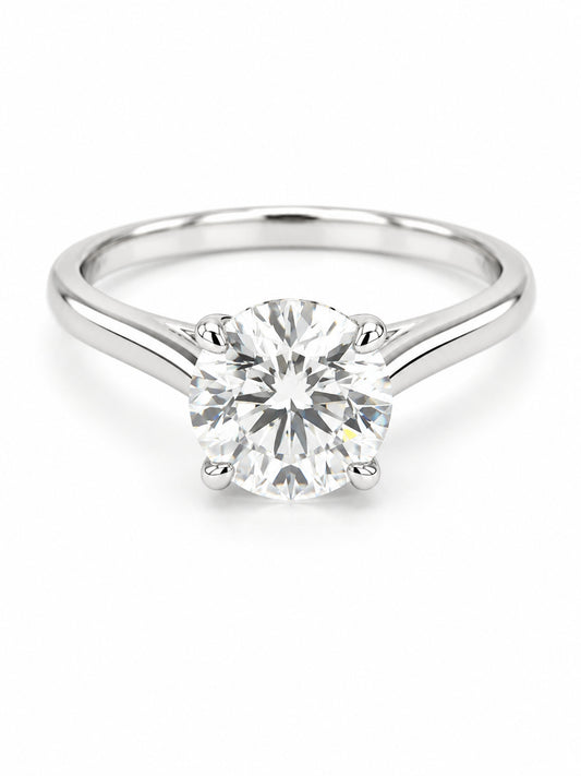 A classic solitaire engagement ring featuring a round brilliant-cut diamond set in a polished white gold metal band, shown on a clean white background.