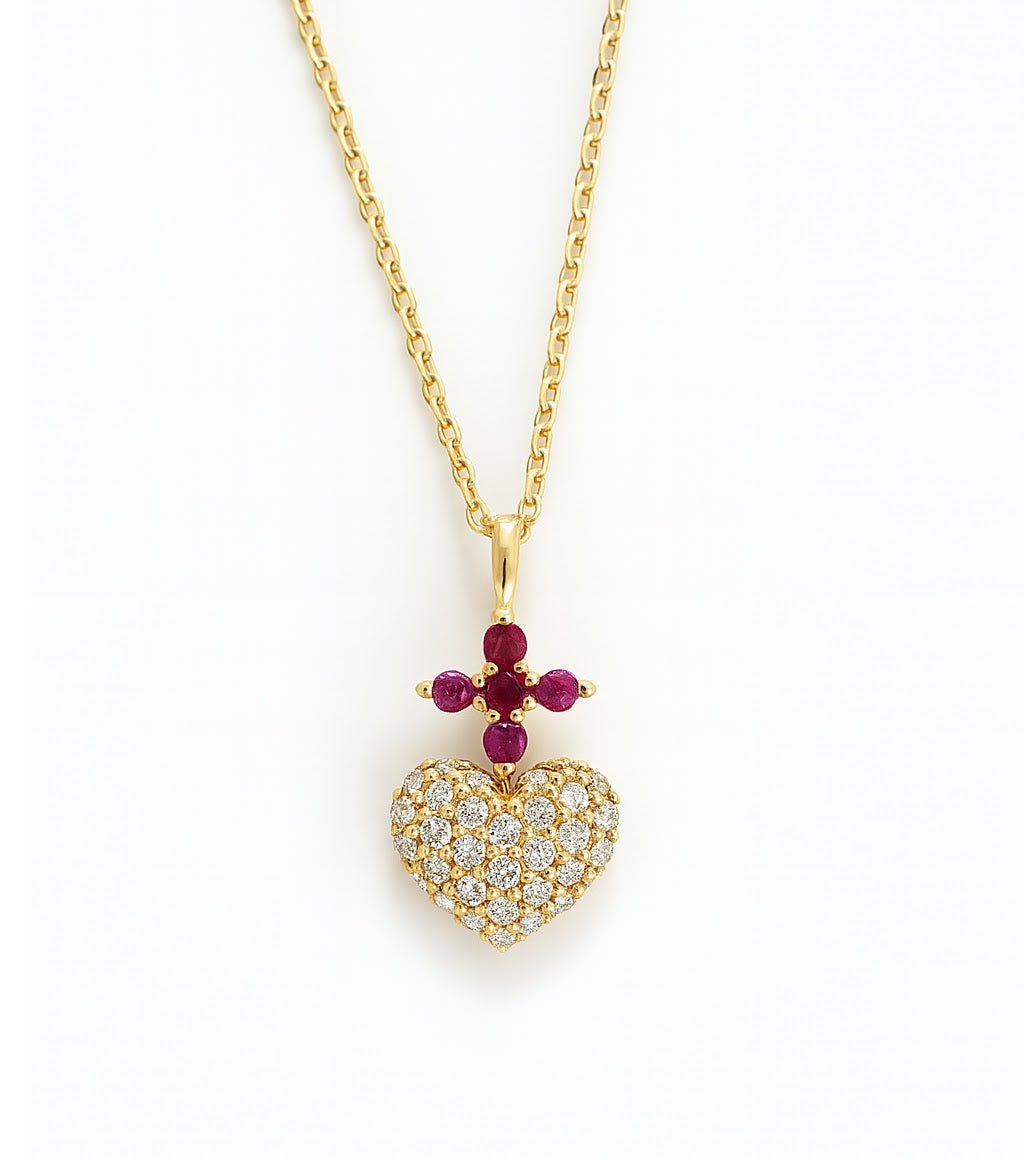 Gold necklace with a diamond heart-shaped pendant and red ruby cross gemstones representing the Sacred Heart of Jesus on a white background