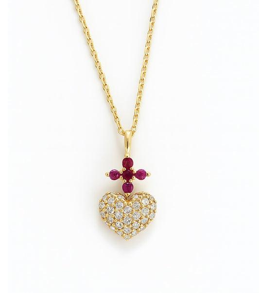 Gold necklace with a diamond heart-shaped pendant and red ruby cross gemstones representing the Sacred Heart of Jesus on a white background