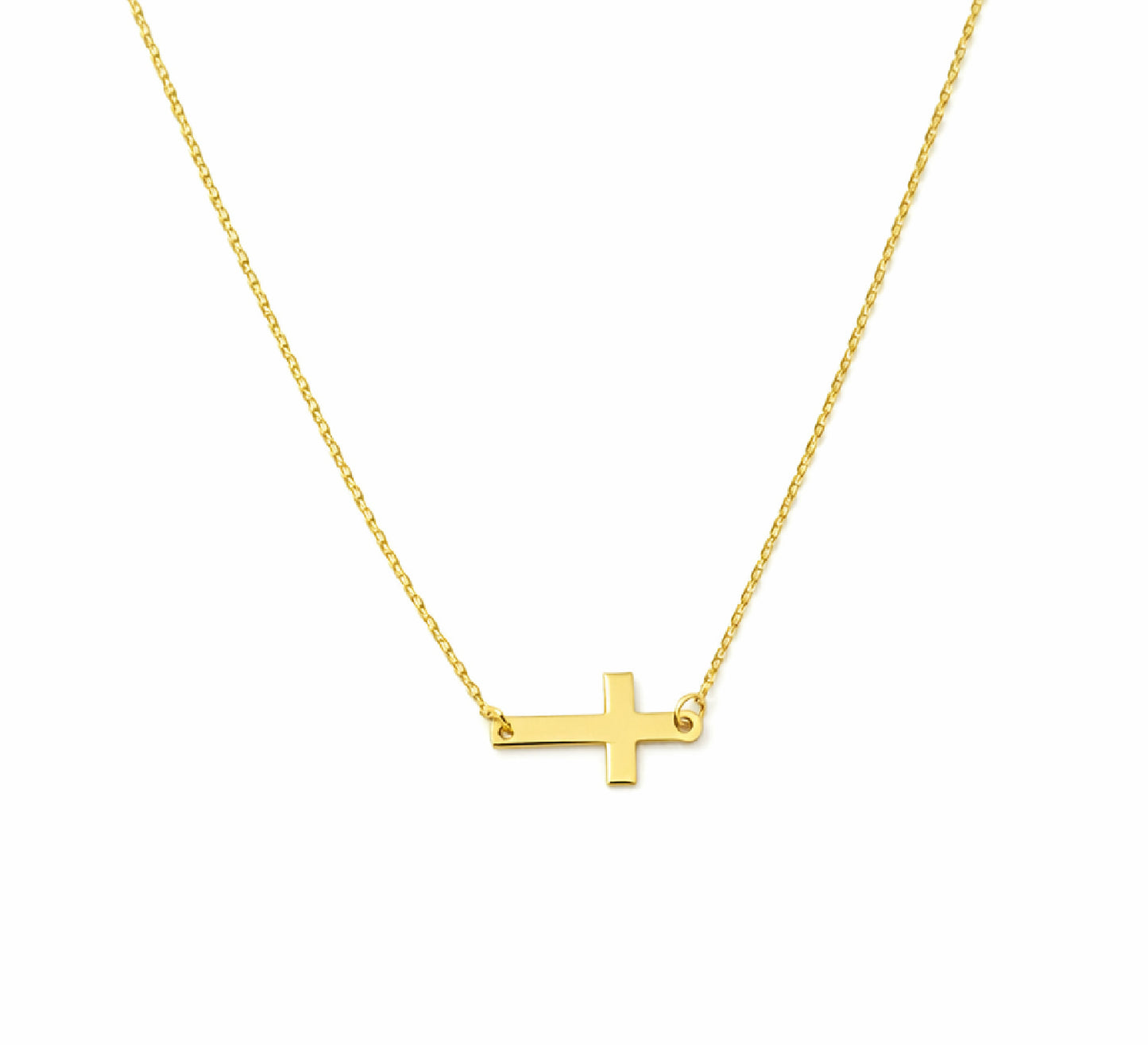 Gold sideways cross necklace on a white background