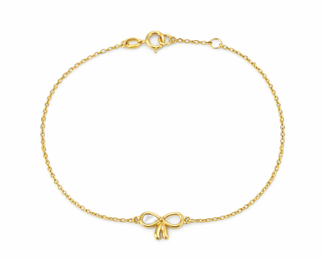 14K Gold bracelet with single mother of pearl bow charm on a cable chain on a white background