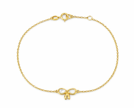 14K Gold bracelet with single mother of pearl bow charm on a cable chain on a white background