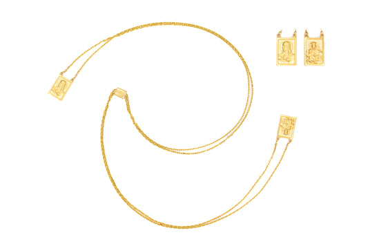 A small gold-colored double medal scapular necklace with two square medals and a tubing chain.