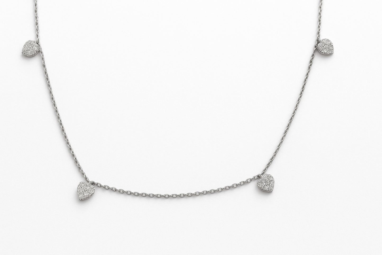 White Gold necklace with diamond pave heart-shaped pendants dangling from a chain on a white background