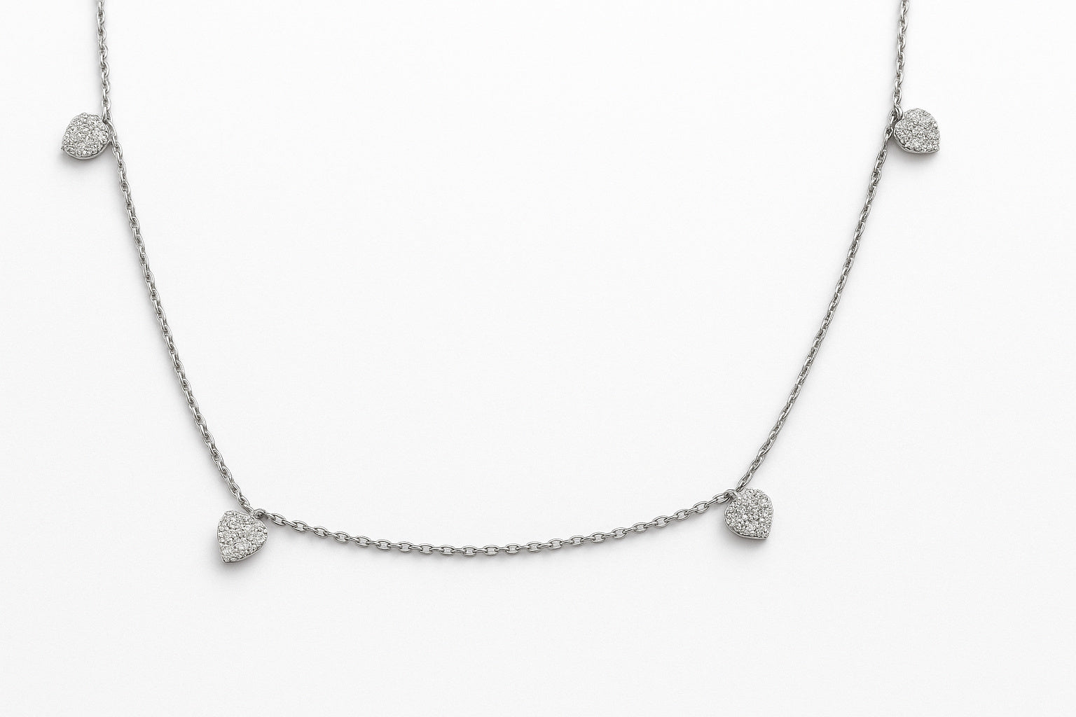 White Gold necklace with diamond pave heart-shaped pendants dangling from a chain on a white background