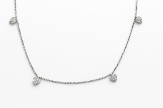 White Gold necklace with diamond pave heart-shaped pendants dangling from a chain on a white background