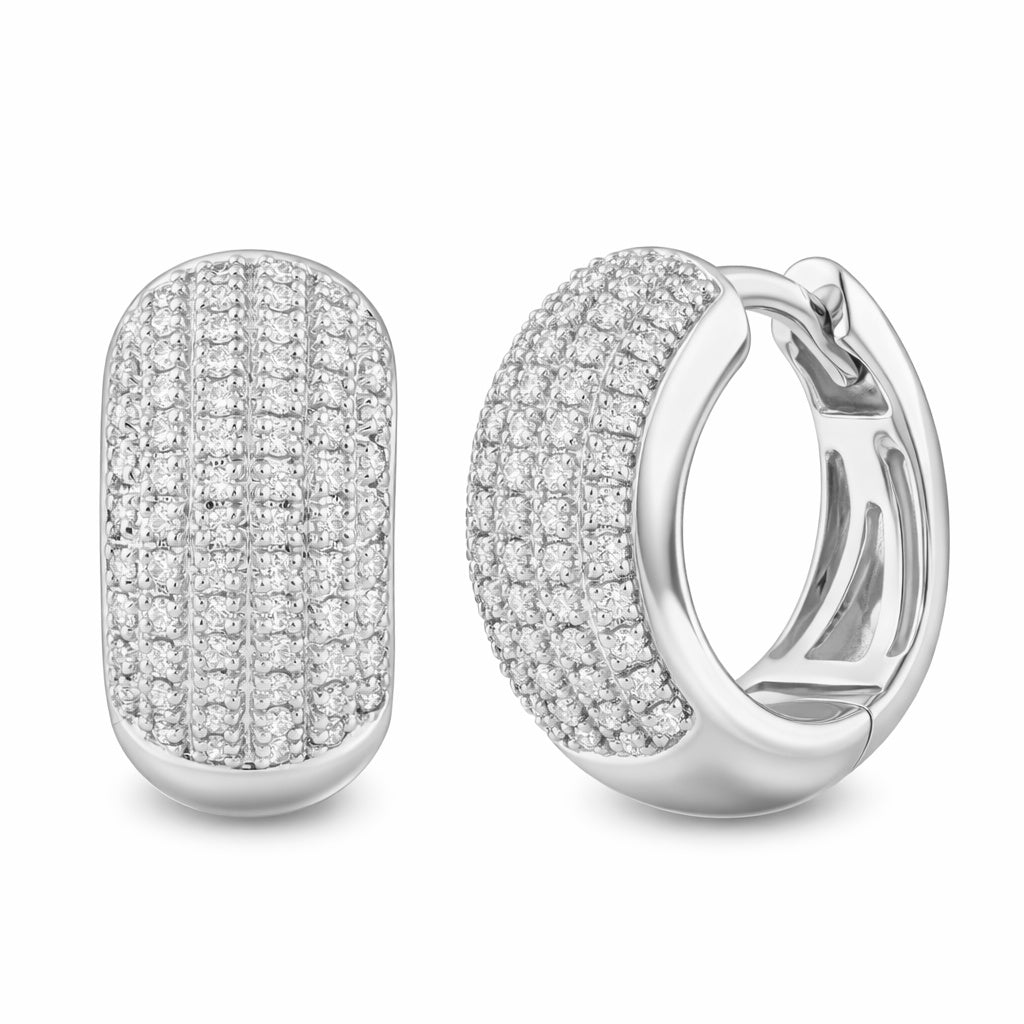A pair of 14K white gold dome pave diamond huggie earrings with a uniform sparkle pattern created by the arranged diamonds.