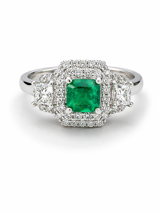 White Gold Engagement Ring with a green emerald gemstone and diamond-studded halo on a white background