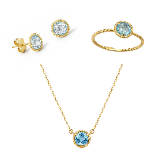 Gold jewelry set with blue topaz gemstones including earrings, a necklace, and a ring on a white background.