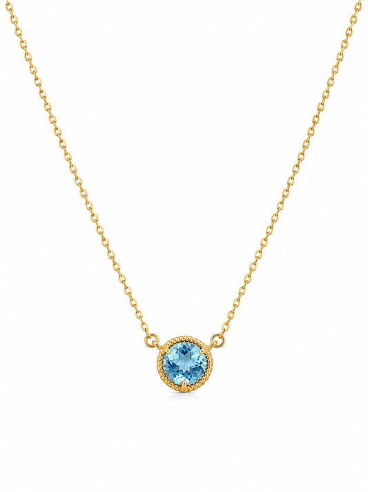 Gold necklace with a blue topaz gemstone pendant on a white background