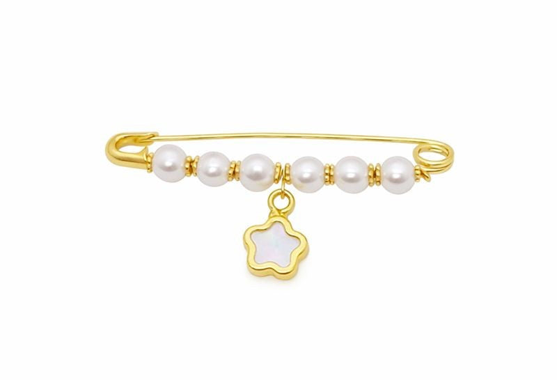 Gold baby pin brooch with pearls and a mother of pearl flower-shaped charm on a white background
