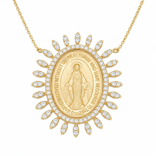 A gold Miraculous Medal pendant necklace on a delicate gold chain, featuring a central oval medal with a depiction of the Virgin Mary and surrounding text, bordered by small pave set diamond stones in a sunburst design, set against a plain white background.