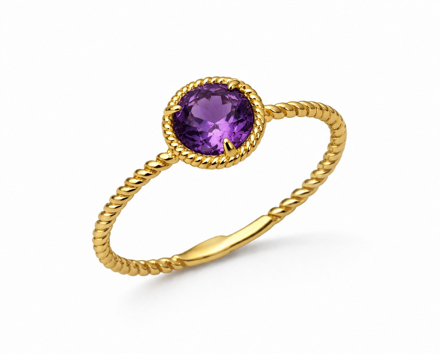 Gold ring with a round purple amethyst gemstone on a white background