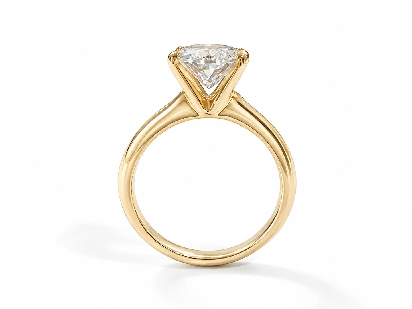 A yellow gold solitaire engagement ring featuring an oval brilliant-cut diamond, set against a clean white background.